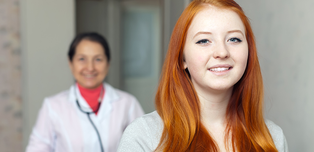 Two female doctors looking at the camera smiling.