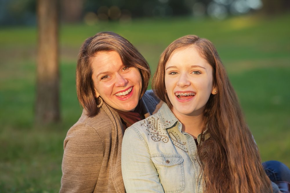 Mission Moment. Laughing Mother And Female Teenager Sitting Together